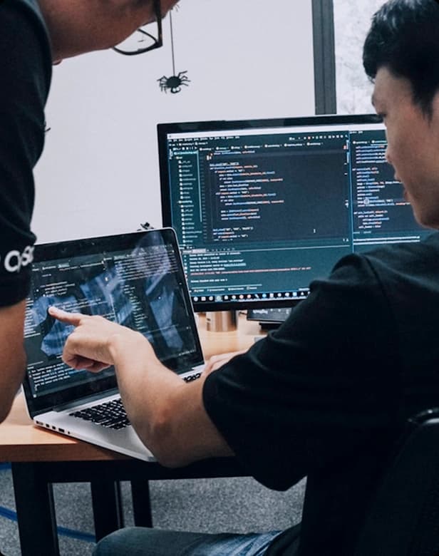 Developer workspace with code on laptop and monitor