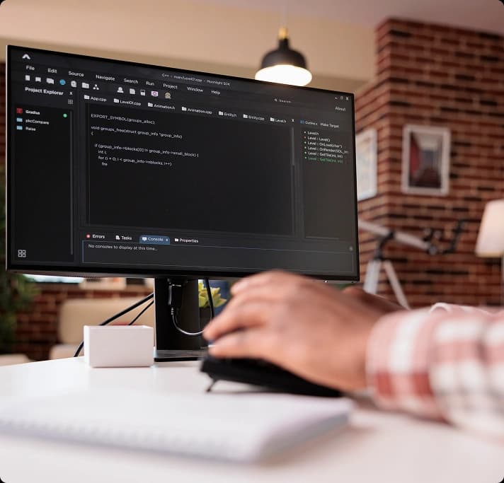 Developer working at a desk with code displayed on a monitor